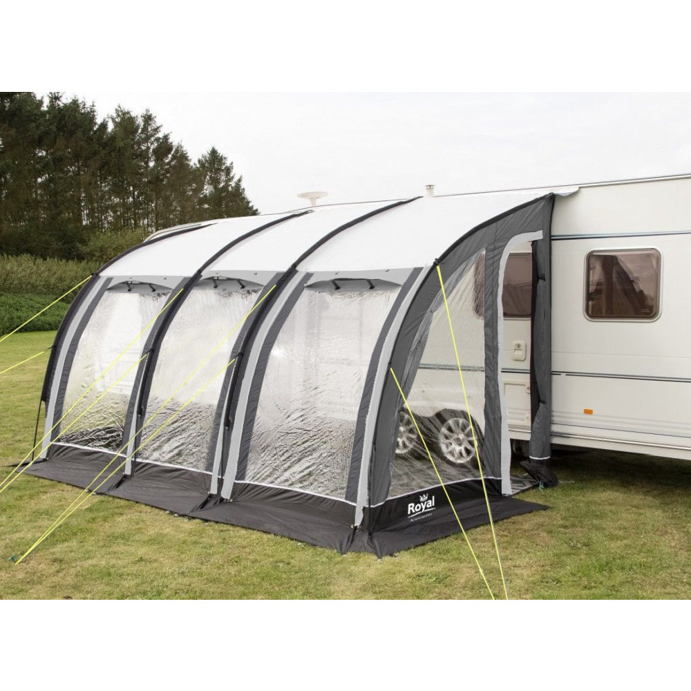Outdoor caravan awning tent with clear panels attached to camper on grassy campsite