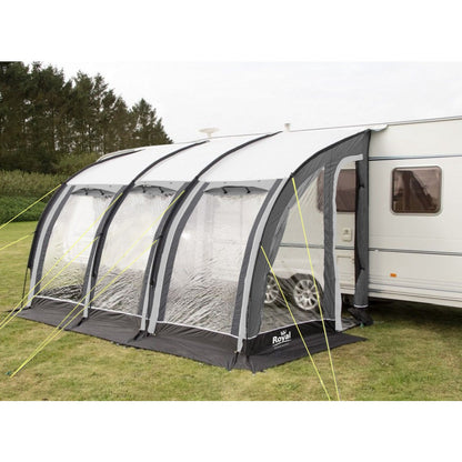Outdoor caravan awning tent with clear panels attached to camper on grassy campsite