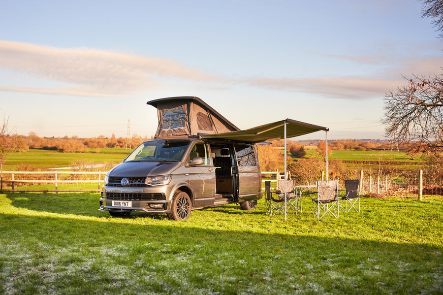 Completed campervan with raised pop-top roof and side awning